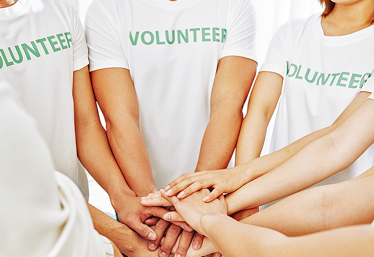 group of volunteers with hands stacked