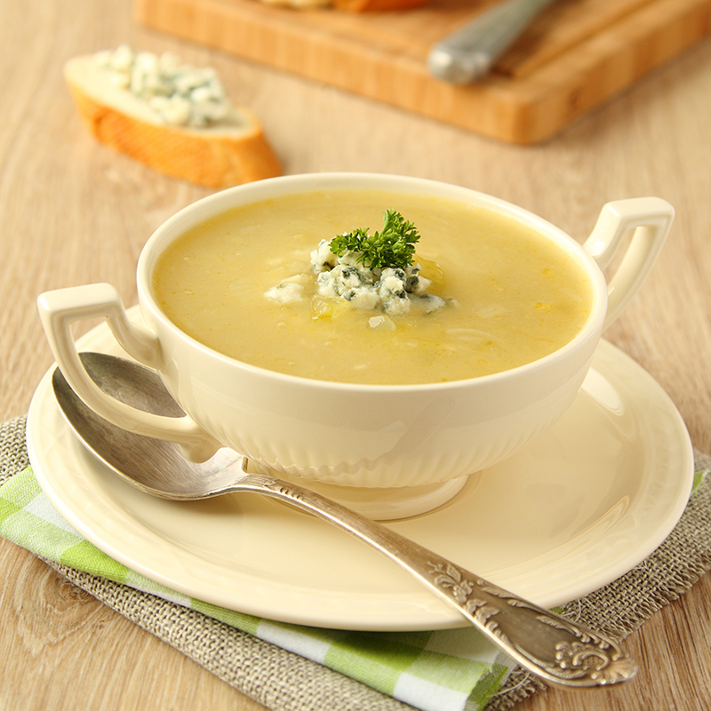 Homemade onion soup with celery and blue cheese on wooden background